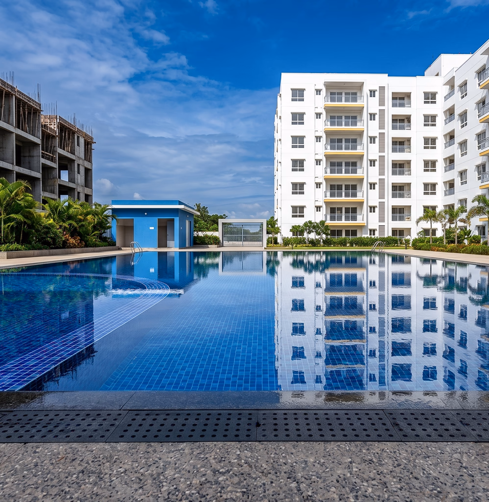Acheter un appartement à Tanger — résidence neuve avec piscine, immeuble blanc moderne et chantier d'extension à proximité, programme immobilier accompagné par l'agence Conciera