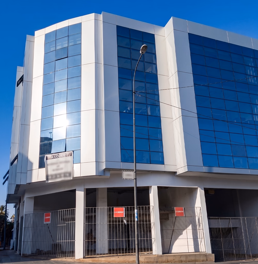 Acheter un bureau à Tanger — immeuble tertiaire moderne d'angle en façade verre miroir bleu et habillage métal blanc, plateaux de bureaux et parking en pied-d'immeuble, projet de siège social accompagné par l'agence Conciera à Marina Bay, Boulevard Mohammed V, Iberia et Tanger Free Zone